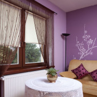 fioletowe ściany z dekorem i jasne rolety